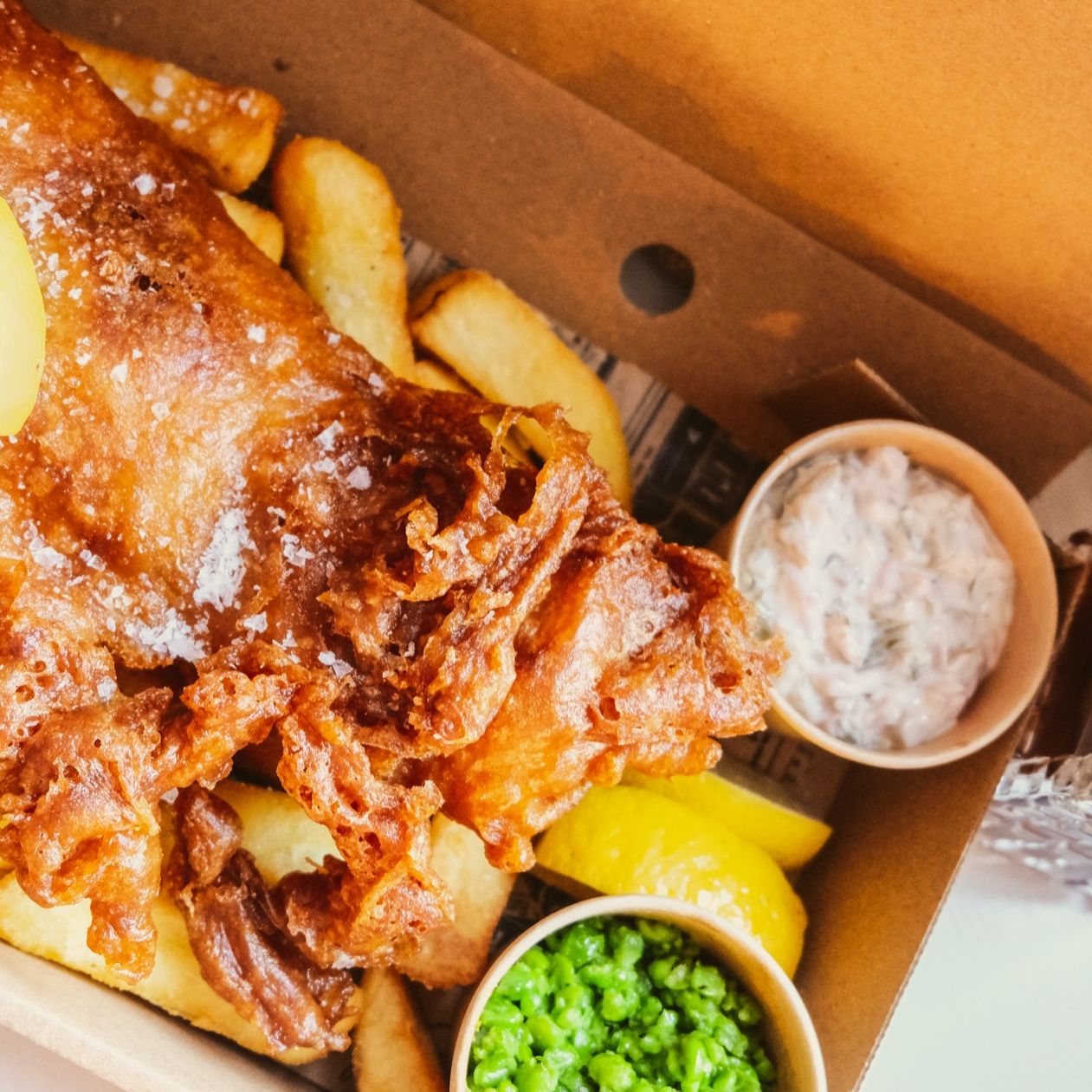 Fish and Chips with lemon wedge and mushy peas